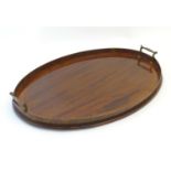 A 19thC mahogany tray of oval form with satinwood inlay and twin brass handles. Approx. 16 1/2" x 23