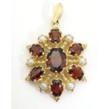 A 9ct gold pendant set with garnets and seed pearls. Approx. 1 1/2" long Please Note - we do not