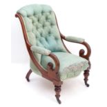 A mid / late 19thC mahogany armchair with a shaped deep buttoned back and scrolled arms above turned