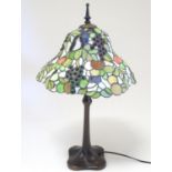 A mid 20thC Art Nouveau table lamp in the style of Tiffany, with bronzed stand and leaded,