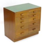 A mid 20thC cedar chest of drawers, comprising two flights of five drawers, with inset green vinyl