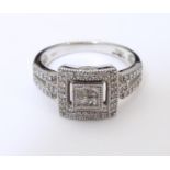 An 18ct white gold ring set with a profusion of diamonds in a squared setting and having further