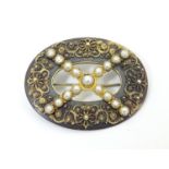 A Victorian tortoiseshell brooch with gilt metal filigree detail and seed pearls. Approx. 1 1/2"