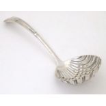 A silver sifter spoon with scalloped shell formed bowl, hallmarked Sheffield 1906, maker Henry