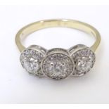 An 18ct gold ring set with tri of diamonds bordered by further diamonds. Ring size approx M 1/2