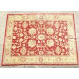 Carpet / Rug : A red ground rug with cream/beige floral and foliate decoration within a beige ground