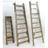 Ladders : Two mid-20thC wooden vintage industrial ladders, together with a stepladder, the largest