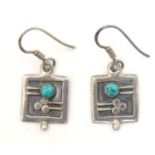 A pair of silver earrings with abstract decoration and set with turquoise cabochon Approx 1" long
