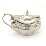 A silver mustard pot, hallmarked Birmingham 1919, maker Joseph Gloster Ltd. with blue glass liner.