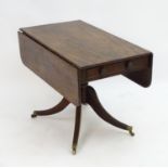 A mid 19thC mahogany Pembroke table with a rectangular top flanked by drop flaps to each side,