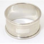 A silver napkin ring with engine turned decoration, hallmarked Birmingham 1960, maker H. Bros.
