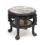 A late 19thC oriental carved hardwood table with an inset marble top above a carved frame and marble