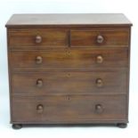 A late 19thC oak and mahogany chest of drawers with a rectangular top above two short over three