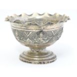A white metal pedestal dish with flared rim and Indian deity decoration. Approx. 2 1/4 "high