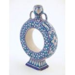 A moon flask / doughnut vase with Persian style palette and decorated with floral detail. Approx. 9"