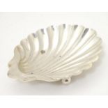 A silver butter dish of scallop shell form. Hallmarked Sheffield 1906 maker Walker & Hall. Approx 5"