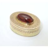 A Victorian yellow metal vinaigrette with engraved decoration set with garnet cabochon to top,