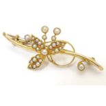 A 15ct gold brooch with floral detail set with seed pearl. Approx. 2" wide Please Note - we do not