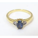 A 9ct gold ring set with green topaz flanked by diamonds . Ring size approx N Please Note - we do