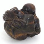 A carved wooden sumo wrestler rolled in a ball. Approx. 3" Please Note - we do not make reference to