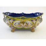 An Italian faience planter of oblong form on claw feet with panelled grotesque decoration