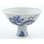 A Chinese blue and white dragon stem bowl with a raised foot. The bowl decorated with two dragons