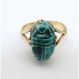 An Egyptian revival gold ring with ceramic scarab beetle decoration to top. Ring size approx. size 9