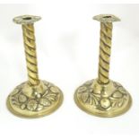 A pair of 19thC brass candlesticks with twist columns and embossed floral detail. Approx. 10"