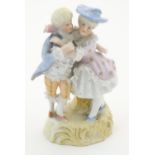 A Continental figural group depicting a man and woman in 18thC dress with porcelain lace detail