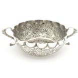 A Portuguese silver twin handled bowl with embossed decoration. Marked under. 7 1/2" wide overall.