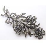 A silver brooch / clip of floral sprig form with marcasite decoration and unusual hinged central