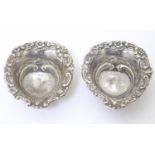 A pair of silver bonbon dishes of heart form on 3 ball feet, hallmarked Chester 1898, maker James