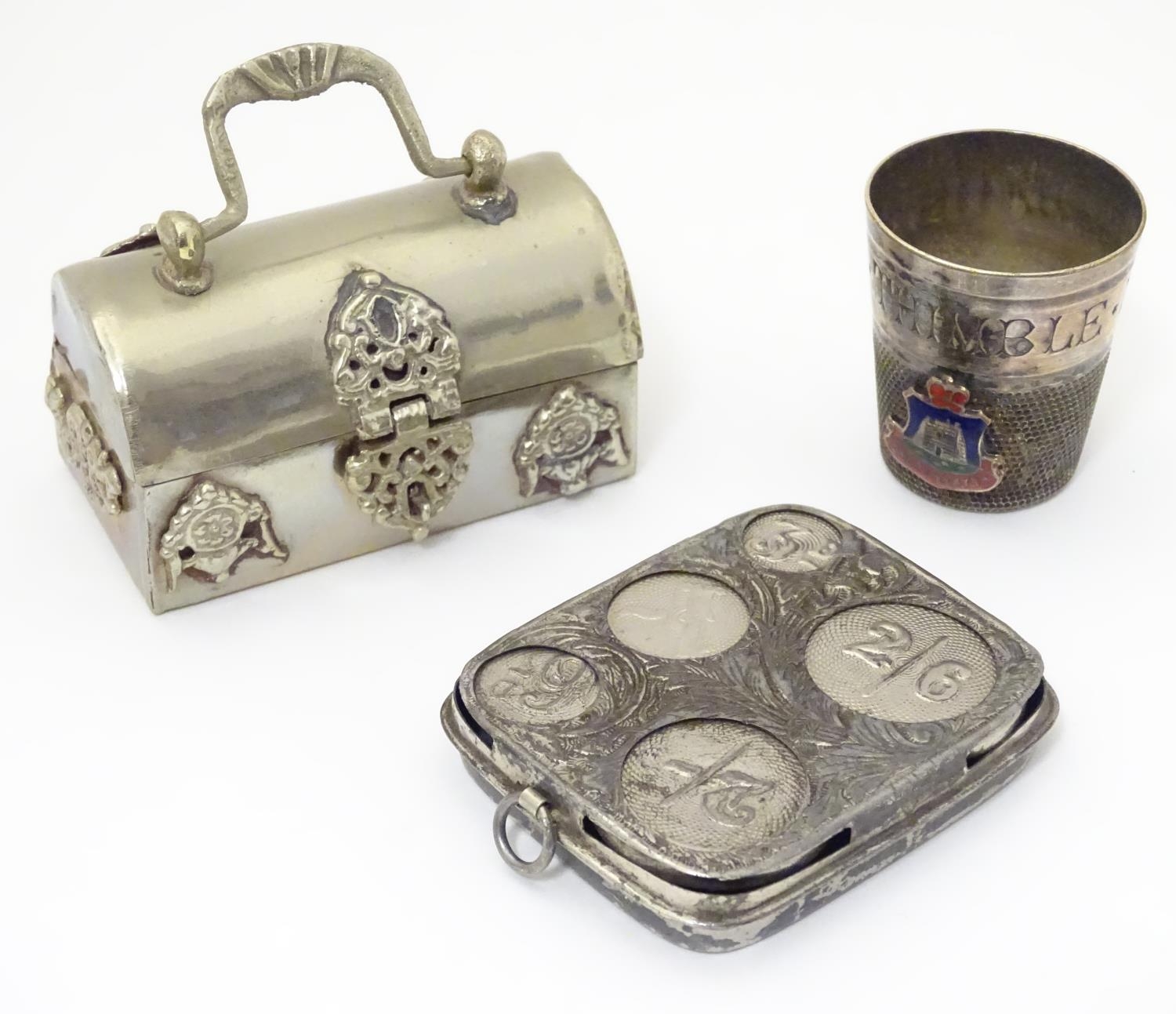 Three silver plate items comprising a coin holder, small box of casket form and an oversized thimble