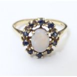 A 9ct gold ring set with central opal bordered by blue spinel. Ring size approx P Please Note - we