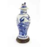 A Chinese blue and white vase and cover with floral, foliate and bird detail. The lid with foo dog