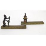 Two early 20thC African bronze knife rests, one depicting a male Tribal figure harvesting fruit, the