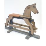 Toy: A 20thC scratch built child's rocking horse with a trestle base and polychrome decoration.