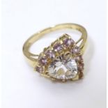 A 9ct gold dress ring set with central white stone bordered by pink stones . Ring size approx N