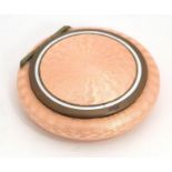 A pink guilloche enamel powder compact of circular form with internal mirror. Approx. 2 1/4"