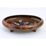A Bursley Ware footed water bowl of oval form with a lustre glaze and floral and fruit decoration.