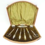 A manicure set with silver handled tools and silver lidded glass pots together with nail scissors (