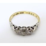 An 18ct gold ring set with trio of diamonds in a platinum setting. Ring size approx O Please