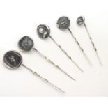 Five assorted white metal stick pins surmounted by various armorial / seal decoration. Largest