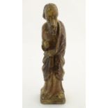 A 19thC carved wooden sculpture depicting an Apostle / Saint, possibly Saint Joseph holding a