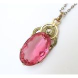 A n Art deco pendant set with pink tourmaline coloured facet cut stone with gilt metal mounts and