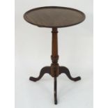 A late 18thC yew wood tripod table with a dished mahogany table top, having a turned pedestal base