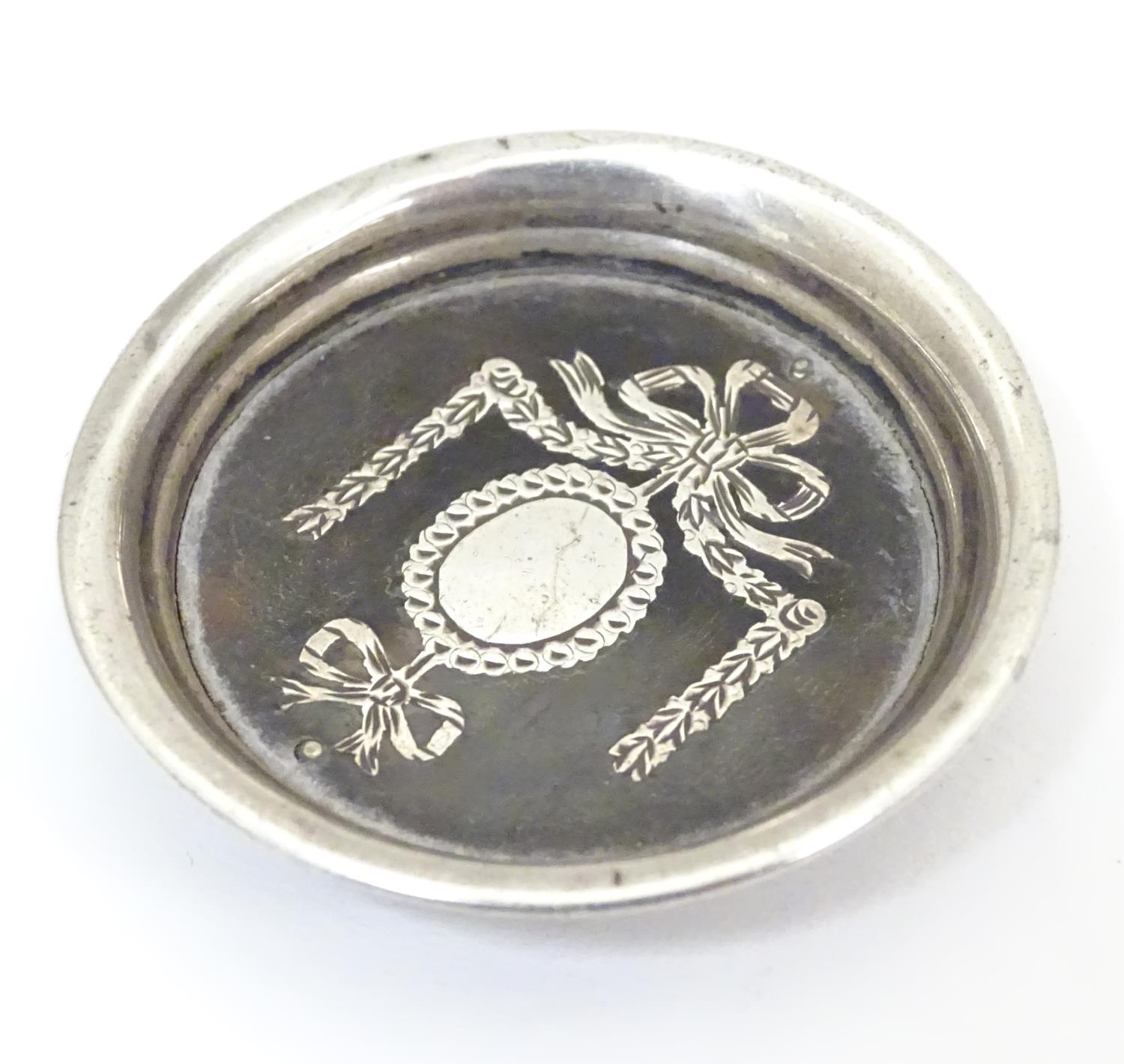 A white metal and tortoiseshell miniature dish with piquet style decoration. Approx. 1 1/2" diameter