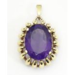 A 9ct gold pendant set with large central amethyst. The whole approx. 1 1/4" long Please Note - we