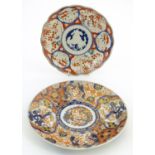 Two Oriental plates, one decorated with panelled detail depicting landscape scenes. The other