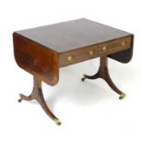 A Georgian rosewood sofa table with a rectangular crossbanded top flanked by two drop leaves, The